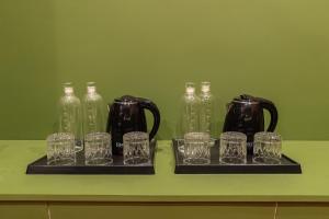 a group of glass cups and bottles on a shelf at Versailles Backpacker Hostel in Pondicherry +41 photos