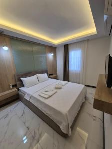 a bedroom with a large white bed with towels on it at Ydora Luxury Hotel in Bodrum City