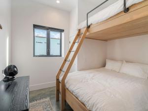 a bedroom with a bunk bed with a ladder at Black Arrow Chalet in Courtenay