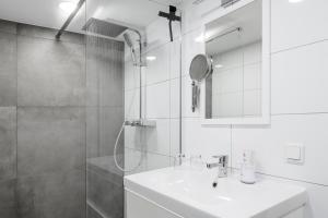 a white bathroom with a sink and a shower at Gästeappartements Mechels in Wilnsdorf +21 photos