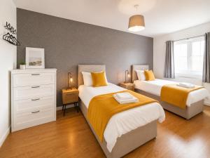 a bedroom with two beds and a white dresser at 3 Bedroom House By Trinity Stays Short Lets & Serviced Accommodation Cambridge With Free WiFi & Parking in Cambridge