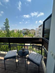 a balcony with two chairs and a table and a view at L7 Urban Studios in Tel Aviv