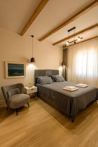 a bedroom with a bed and a chair at Avila Casa in Podgorica