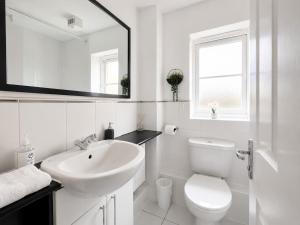 a white bathroom with a sink and a toilet at 3 Bedroom House By Trinity Stays Short Lets & Serviced Accommodation Cambridge With Free WiFi & Parking in Cambridge
