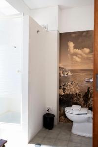 a bathroom with a painting of the ocean and a toilet at WOT Sarrazola Soul in Sintra +62 photos