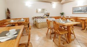 a dining room with wooden tables and chairs at Albergo Caravasc in Livigno