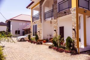 a house with a car parked in the driveway at Leaves & Stones in Kwedonu