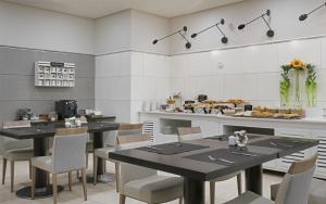 a dining room with tables and chairs and a counter at NH Ciudad Real in Ciudad Real