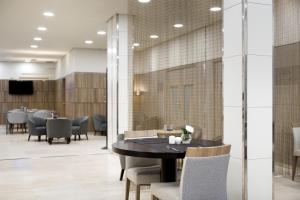 a dining room with a black table and chairs at NH Ciudad Real in Ciudad Real