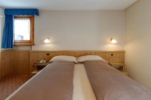 two beds are lined up in a room at Albergo Caravasc in Livigno +31 photos