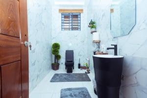 a bathroom with a sink and a toilet and a mirror at Leaves & Stones in Kwedonu +38 photos
