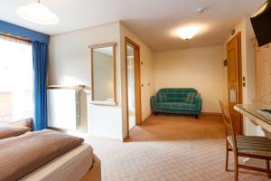 a hotel room with a bed and a chair at Albergo Caravasc in Livigno