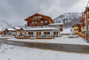 a building in a town with snow on the ground at Albergo Caravasc in Livigno
