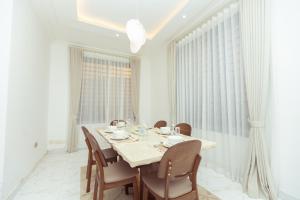 a white dining room with a table and chairs at Leaves & Stones in Kwedonu