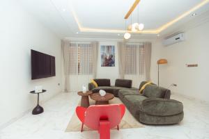 a living room with a couch and a red chair at Leaves & Stones in Kwedonu