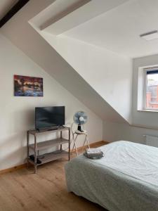 a bedroom with a bed and a desk with a television at Hébergement Citabelle in Dinant