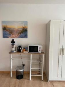 a table with a microwave on it in a room at Hébergement Citabelle in Dinant +10 photos