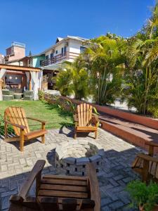 a patio with two chairs and a fire pit at Pousada Makani Kai in Florianópolis