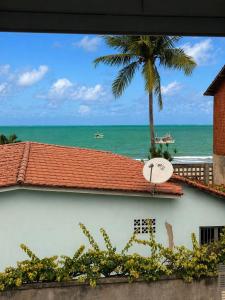 a view of the ocean from a building with a clock at Pousada Maragobeach Suits in Maragogi