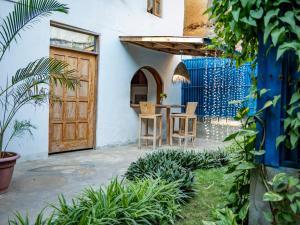 a patio with a wooden door and a table and chairs at Old Stone Boutique Lodge in Bagamoyo