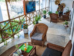 a living room with wicker chairs and a tv at Old Stone Boutique Lodge in Bagamoyo