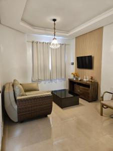 a living room with a couch and a tv at Casa de Charles in Piranhas