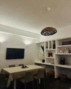 a dining room with a table and a flat screen tv at Aelia in Vári