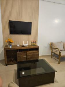 a living room with a flat screen tv on a wall at Casa de Charles in Piranhas