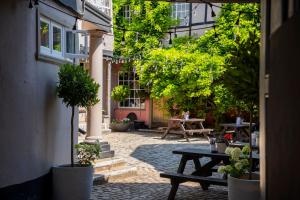 an outdoor patio with a picnic table and trees at The Crown & Thistle, Abingdon, Oxfordshire - Acorn Pubs in Abingdon