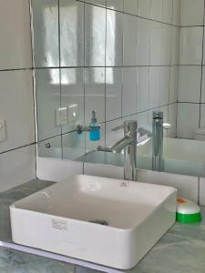 a white sink in a bathroom with a mirror at Bliss home in Watamu +27 photos