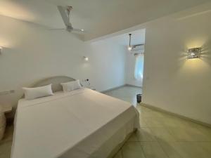 a bedroom with a large white bed in a room at Bliss home in Watamu