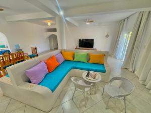 a living room with a couch with colorful pillows at Bliss home in Watamu