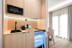 a kitchen with a sink and a microwave at Medichë Rooms General Ricardos in Madrid