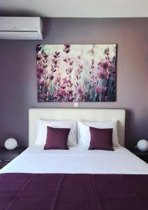 a bedroom with a bed with a painting on the wall at Villa Selene in Alonnisos +43 photos