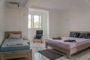 a bedroom with two beds and a chair in it at BEB House Ulcinj in Donji Štoj