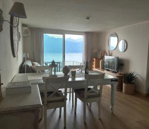a living room with a table and chairs with a view of the ocean at Suite Incanto lago di Garda in Torri del Benaco