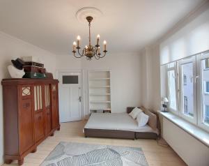 a bedroom with a bed and a chandelier at Kamienica u Artystów in Sopot