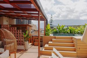 a balcony with wooden stairs and a swimming pool at Pranik Living Wellness Coliving Laureles Medellin in Medellín