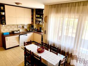 a kitchen with a dining room table and a window at Kiwi house in Podgorica