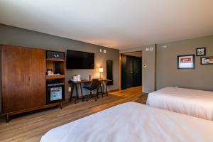 a hotel room with a bed and a desk with a television at Four Points by Sheraton Brunswick in Brunswick