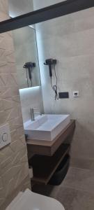 a bathroom with a white sink and a mirror at House K and M in Pag +13 photos