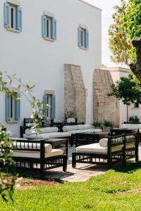 a group of benches and tables in front of a building at Masseria Montelauro in Otranto