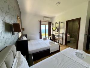 a room with two beds and a view of the ocean at Hotel Victoria in Pogradec