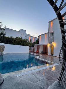a swimming pool in front of a house at Ydora Luxury Hotel in Bodrum City