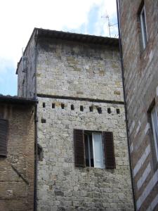 ein Backsteingebäude mit einem Seitenfenster in der Unterkunft Albergo Cannon d'Oro in Siena