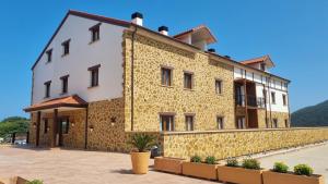 a building with a yellow and white facade at Apartamentos El Jardín de Isla Autocheck-In in Isla