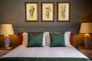 a bedroom with a bed with green and white pillows at The Crown & Thistle, Abingdon, Oxfordshire - Acorn Pubs in Abingdon