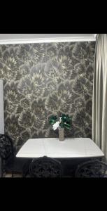 a table with a flower vase on top of a wall at AeroHome 24 -Внимание !!! Только дневное размещение !!! NO OVERNIGHT !!! Заселение с 12 00 и выселение до 23 00 !!! in Chişinău