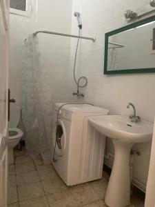 a bathroom with a washing machine and a sink at Nice house ideally located in Dar Tahar Zaouch