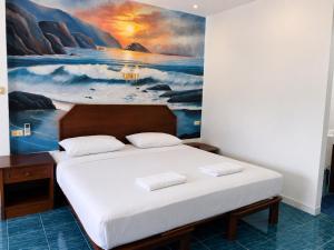 a bed in a room with a painting on the wall at Baan Mon Hill in Patong Beach